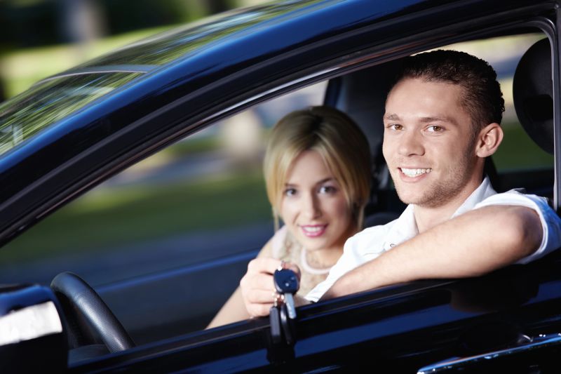 Happy couple with the car keys of their holiday rental car